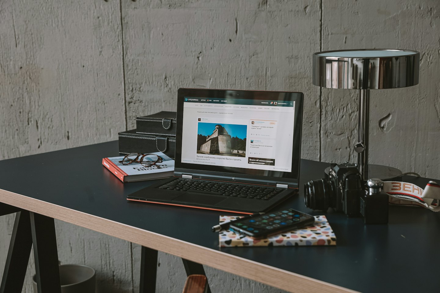 Laptop on a desk surrounded by office supplies and decor.